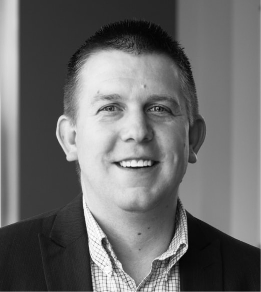 A man in a suit and tie smiling for the camera.