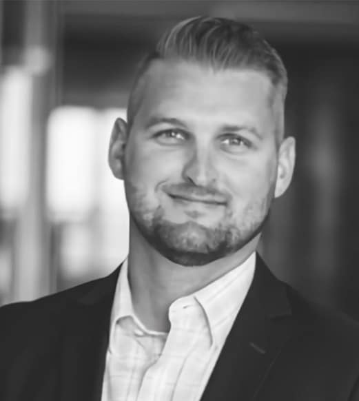 A man in suit and tie smiling for the camera.