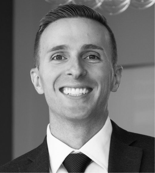 A man in suit and tie smiling for the camera.