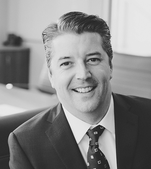 A man in suit and tie smiling for the camera.