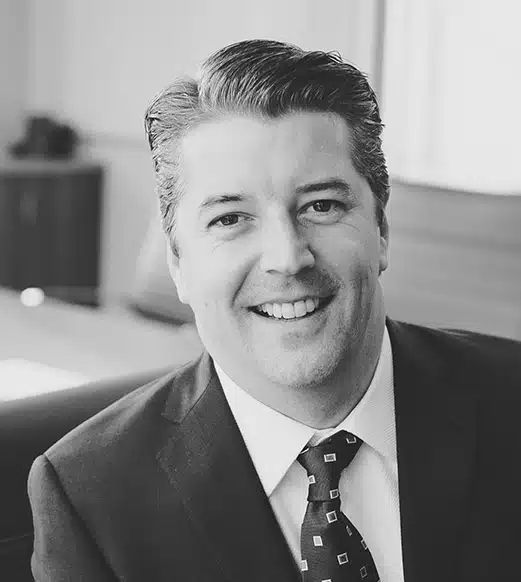 A man in suit and tie smiling for the camera.