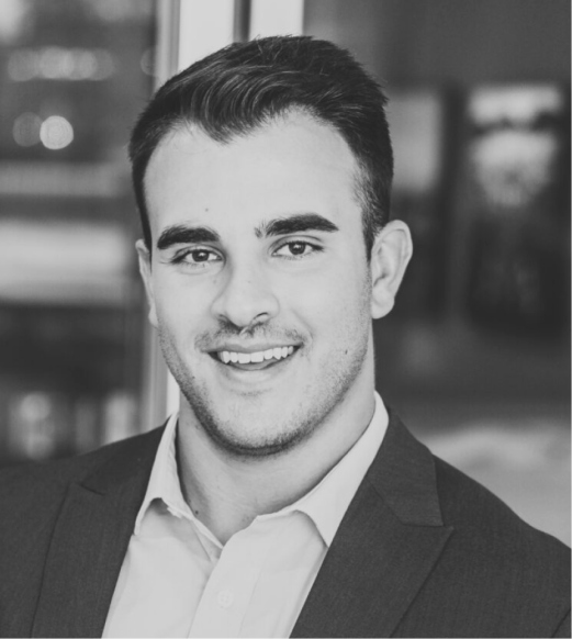 A man in suit and tie smiling for the camera.