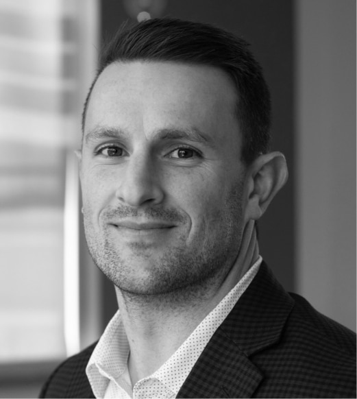 A man in suit and tie smiling for the camera.