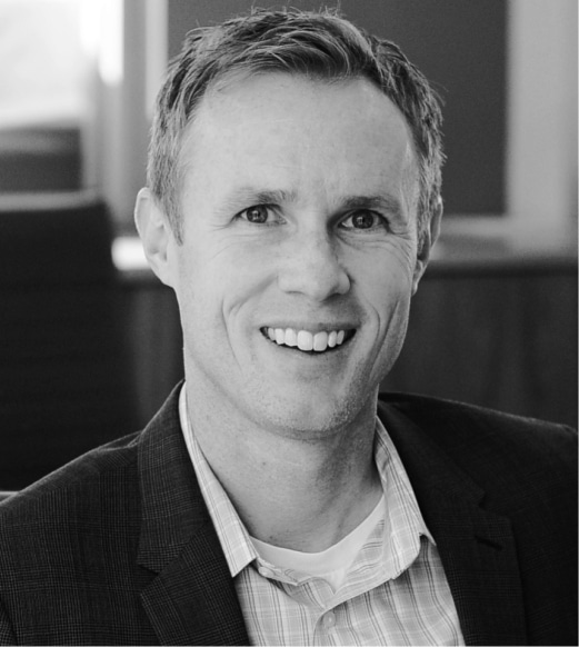 A man in suit and tie smiling for the camera.