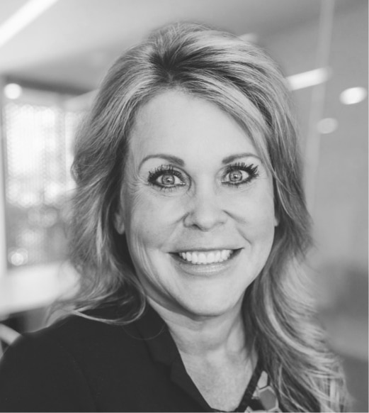 A black and white photo of a woman smiling.