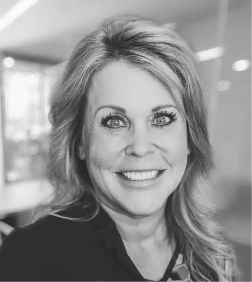 A black and white photo of a woman smiling.