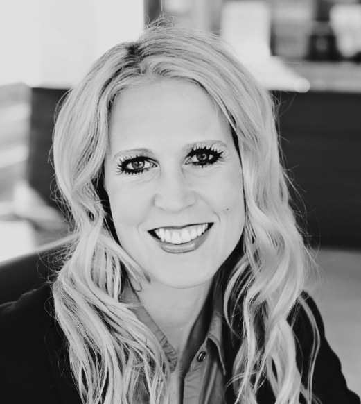 A black and white photo of a woman smiling.