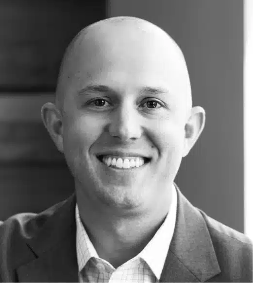 A man with bald head smiling for the camera.