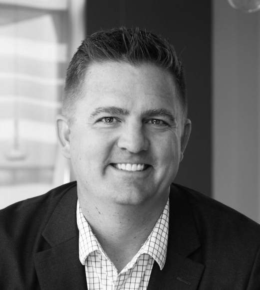 A man in a suit and tie smiling for the camera.