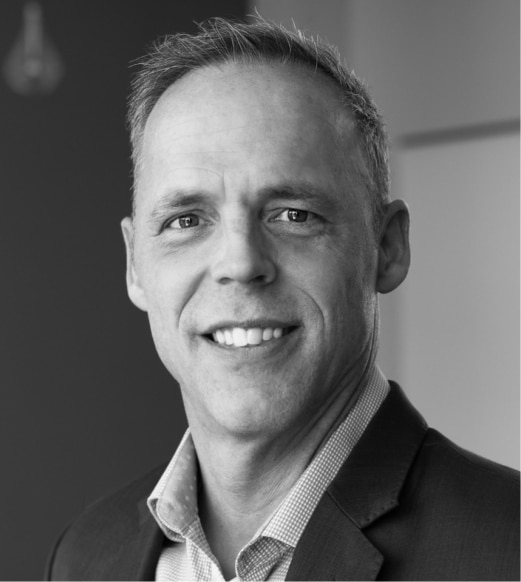 A man in suit and tie smiling for the camera.