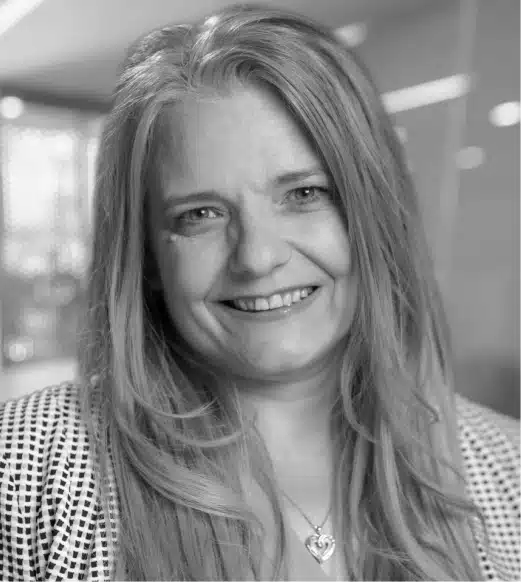 A black and white photo of a woman smiling.