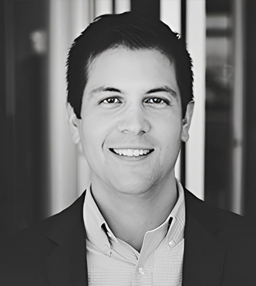 A man in a suit and tie smiling for the camera.