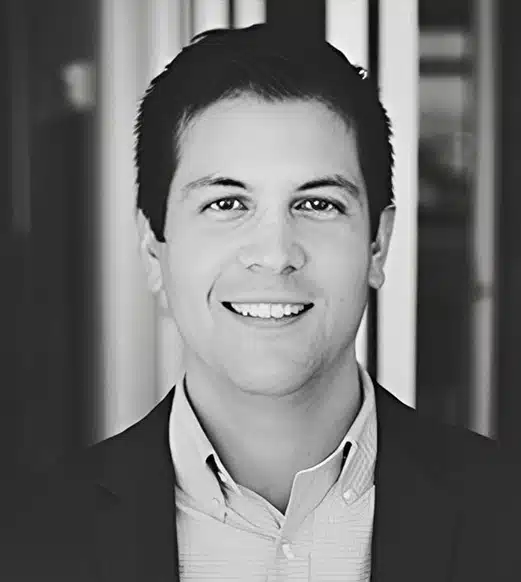 A man in a suit and tie smiling for the camera.