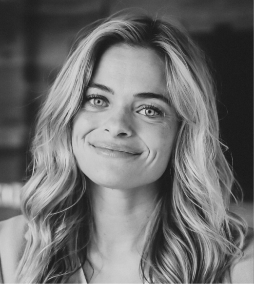 A black and white photo of a woman smiling.