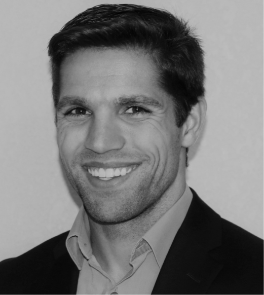 A man in suit and tie smiling for the camera.