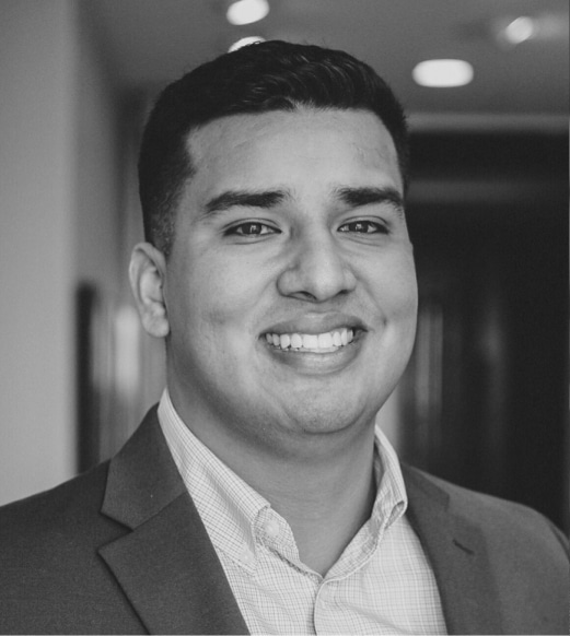 A man in a suit and tie smiling for the camera.