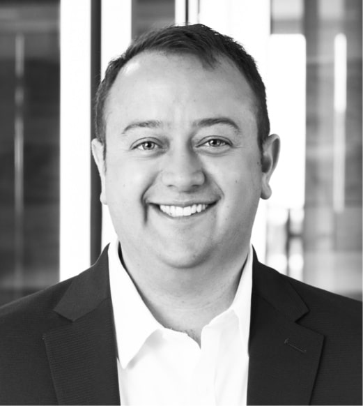 A man in a suit and tie smiling for the camera.