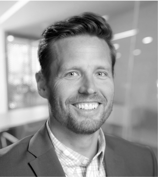 A man in suit and tie smiling for the camera.