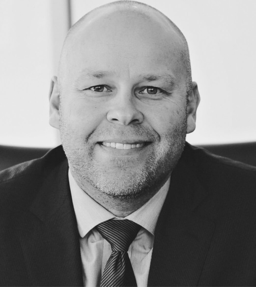 A man in suit and tie smiling for the camera.