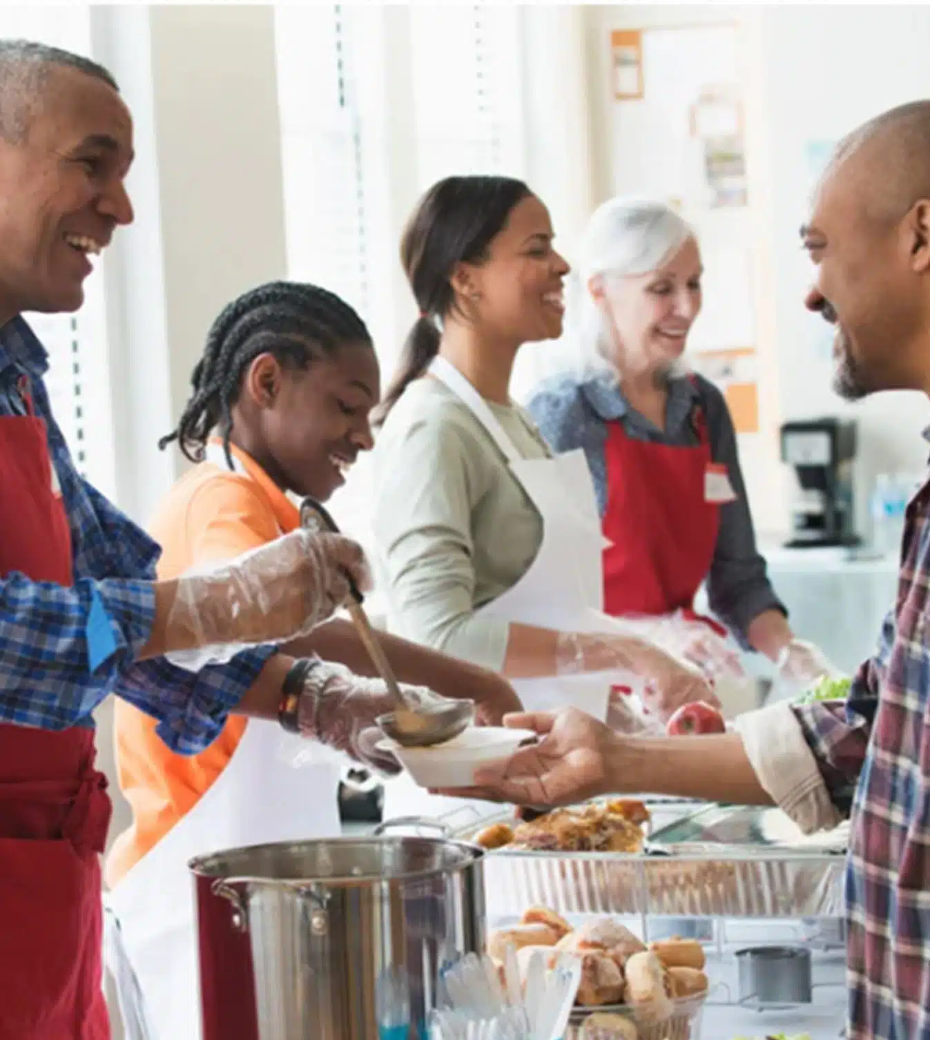 A group of people standing around serving food.