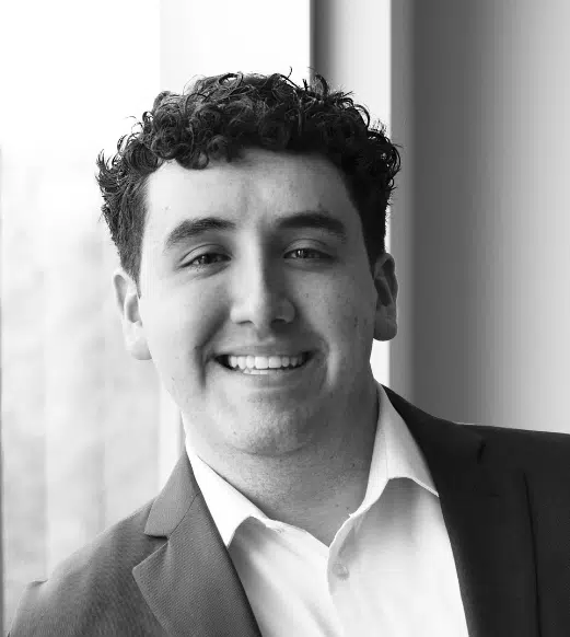 Smiling young man in suit by window