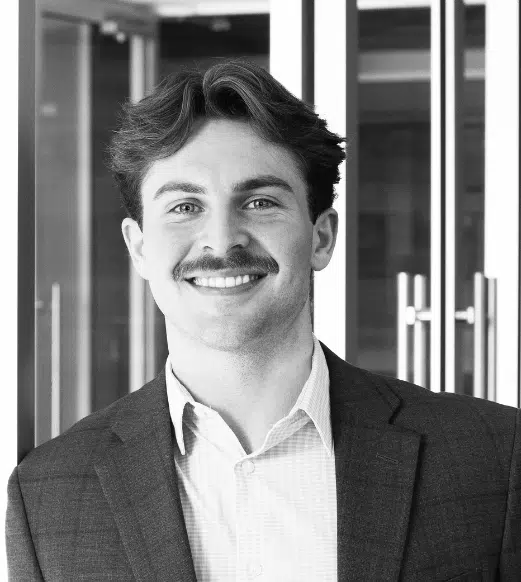 Smiling young businessman with mustache in office